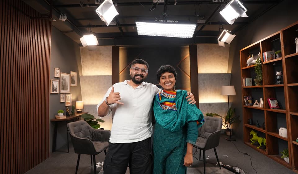 Kavya with a guest on the podcast set